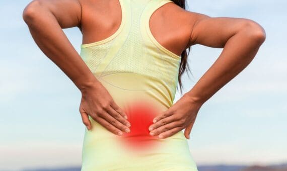 Woman with back pain holding her lower back