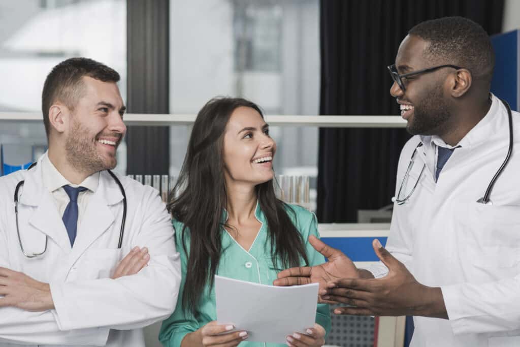 What Is Rheumatology? 9 Group of smiling doctors and a nurse discussing medical documents.