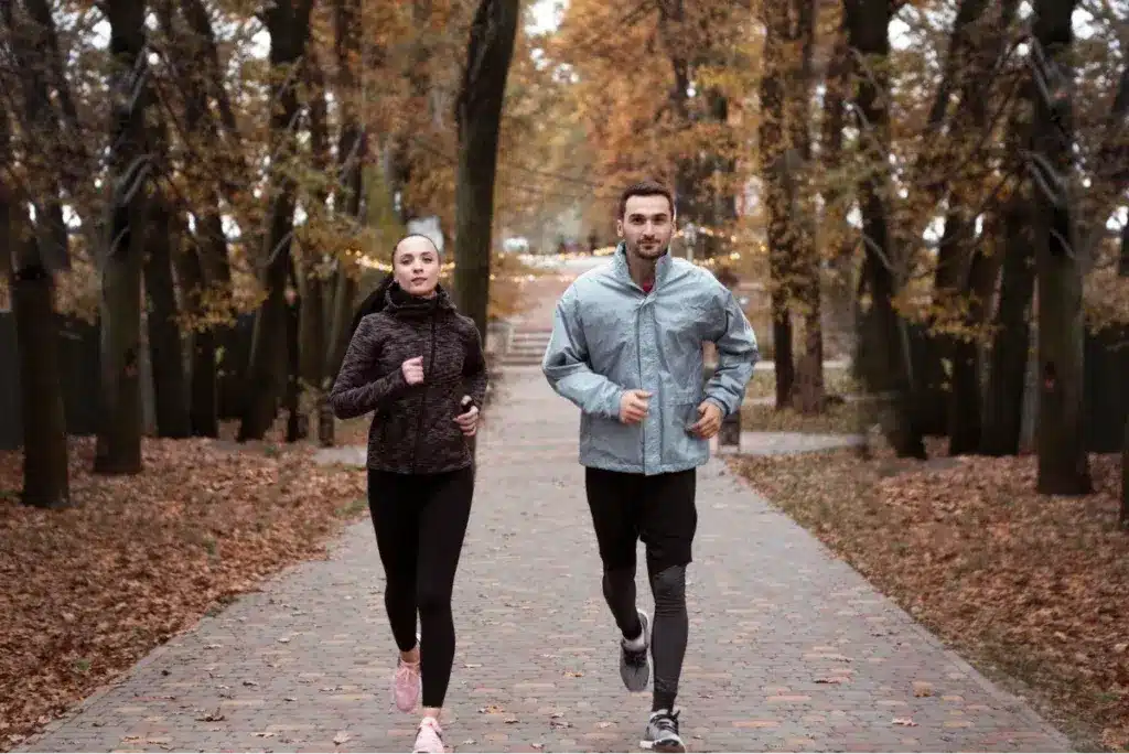 What Is Rheumatology? 7 A man and a woman jogging together in a park during autumn.