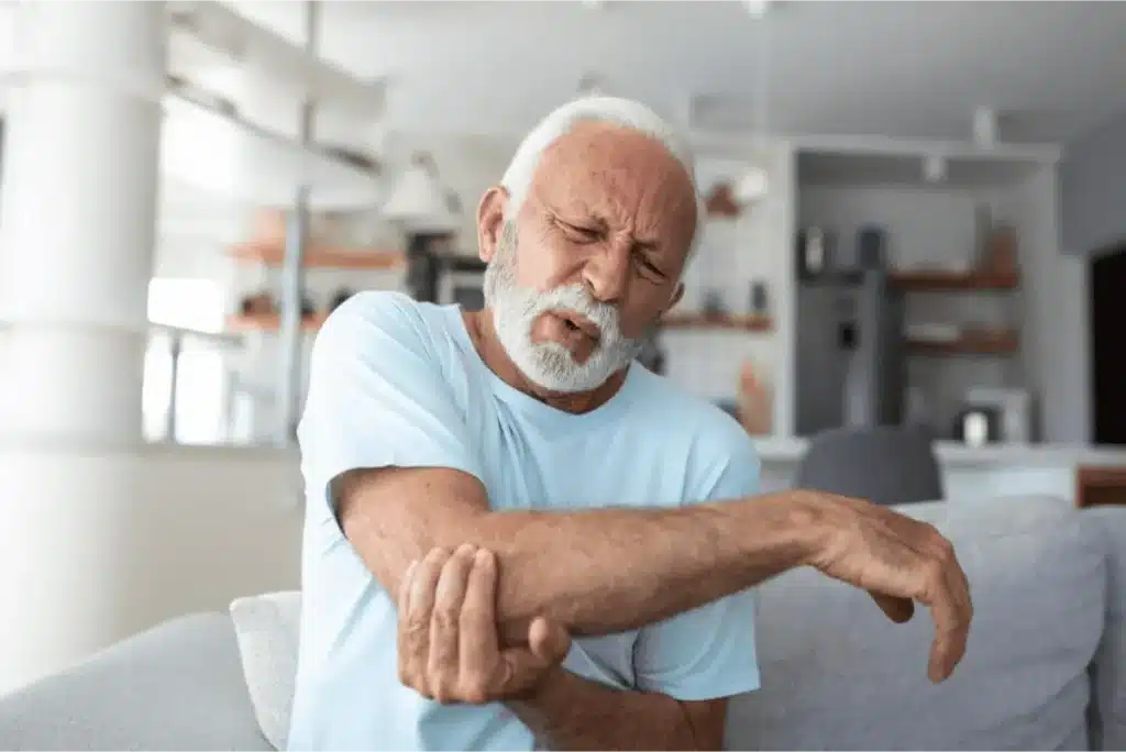 Recognizing the Common Symptoms of Arthritis 6 Elderly man massaging his elbow due to discomfort.