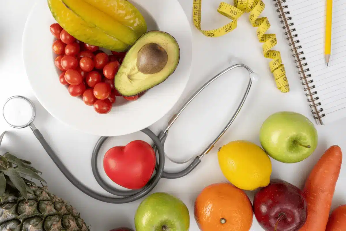 Wellness Services 5 Healthy fruits, vegetables, a stethoscope, and a tape measure on a table.