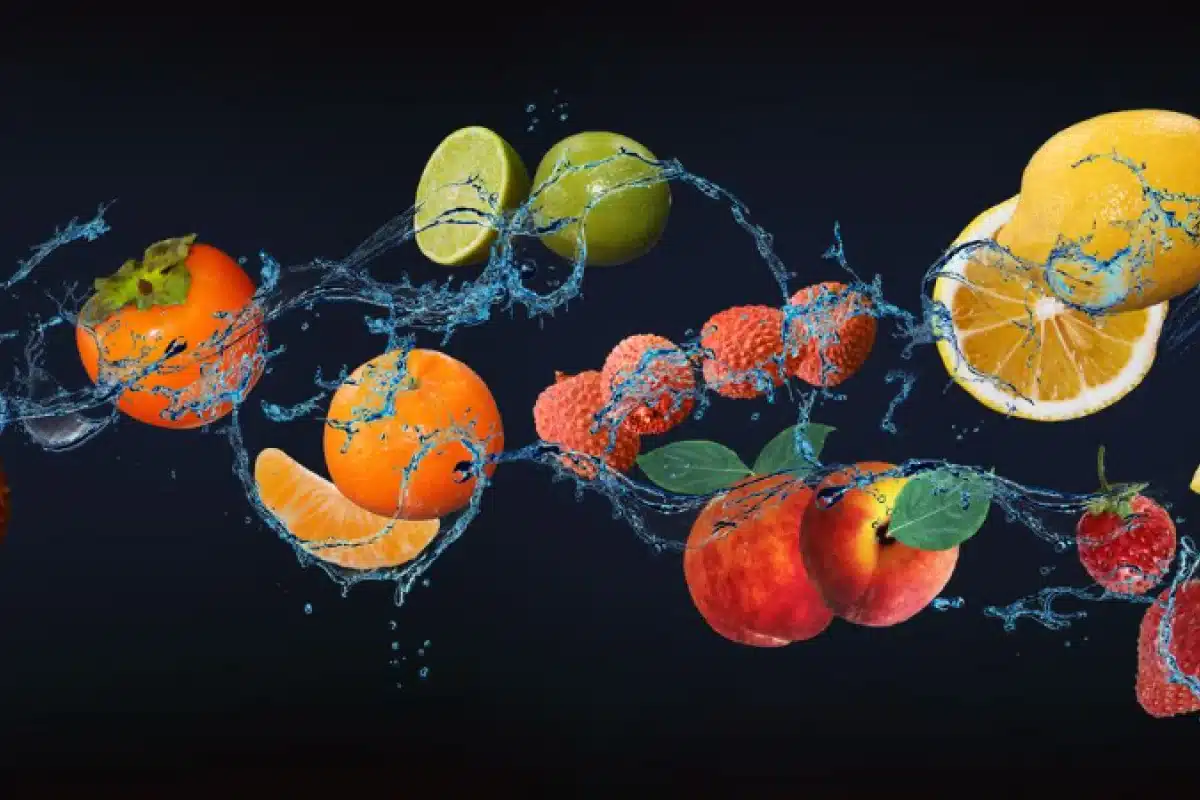 Wellness Services 1 Fruits with splashing water on a dark background.